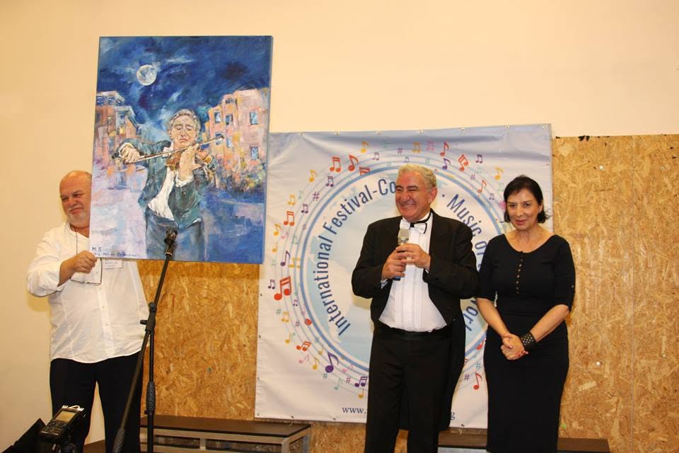 מרים סולוגשווילי באירוע אמנות, עומדת לצד אחת מיצירותיה